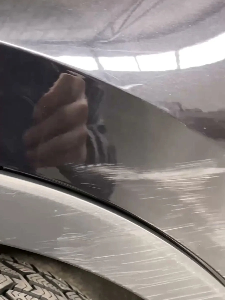 Переднее левое крыло Volkswagen Tiguan до ремонта: краска содрана над колёсной аркой до грунта